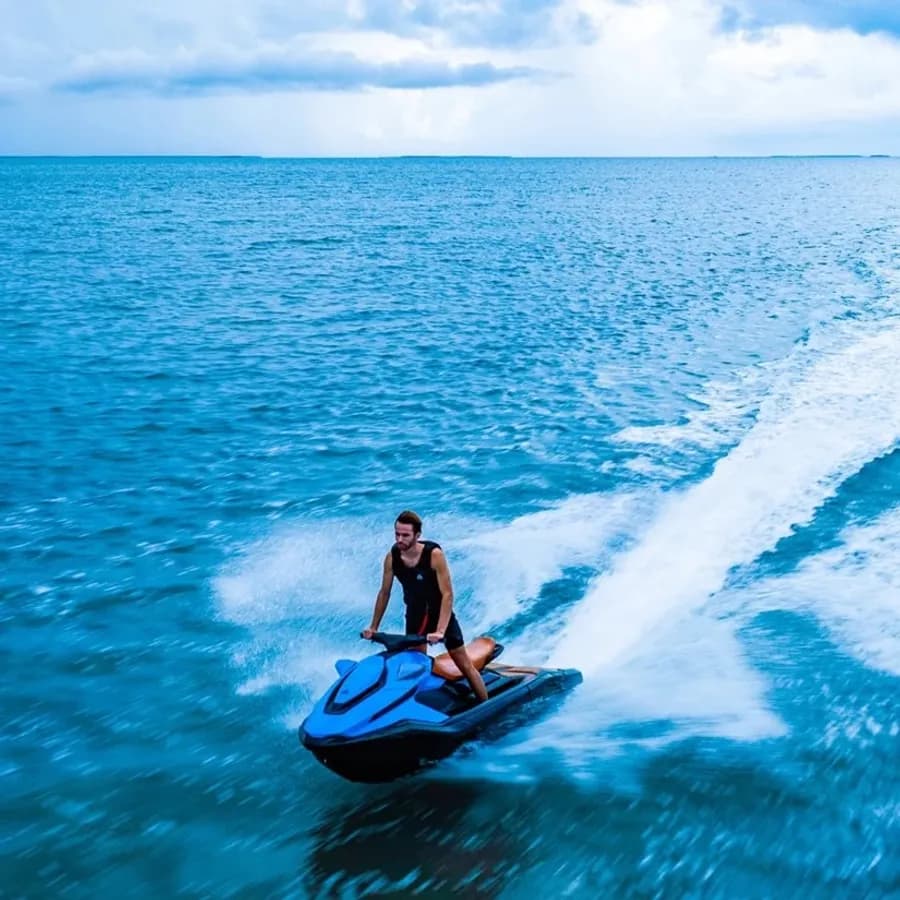 Rider on a blue Taiga Orca WX3 electric personal watercraft carving across open water